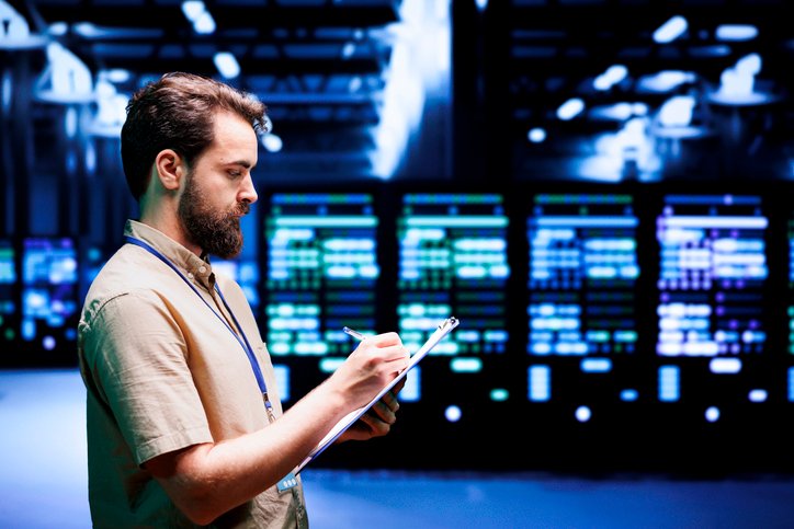 Experienced admin checking high tech data center security to make sure virus protection software is up to date and hackers trying to penetrate systems are not allowed access